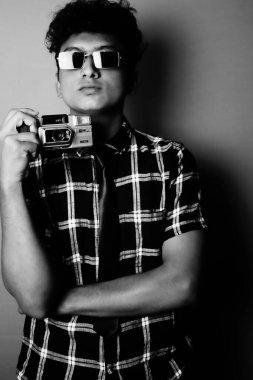 young boy wearing a sun glass and heaving a camera b&w image, b&w