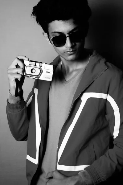 young boy wearing jacket and black glass with camera, black and white image