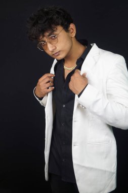 Handsome man wearing eyeglasses standing in front of black background