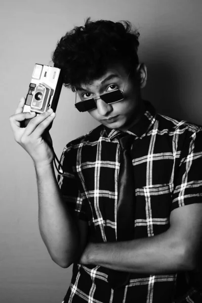 young boy wearing a sun glass and heaving a camera b&w image b&w