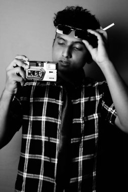 young boy wearing sun glass and shirt with camera looking in camera, black and white image