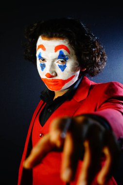 man in joker makeup , looking front in scary evil eyes , image