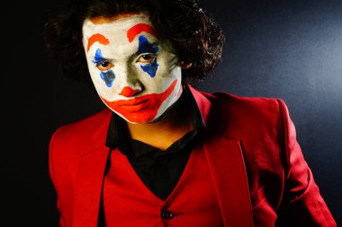 male in joker face , with red formal outfit and scary look image