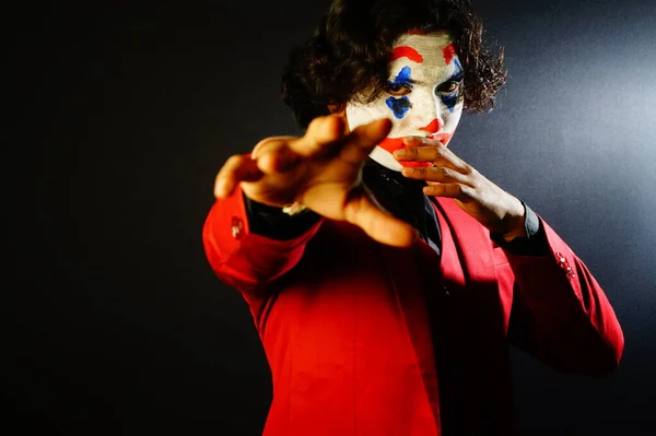 male in joker face with scary eyes pose , image