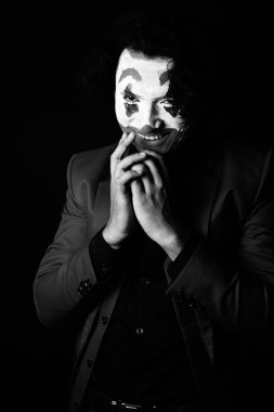 man in joker face makeup,crazy smiling,black and whit image