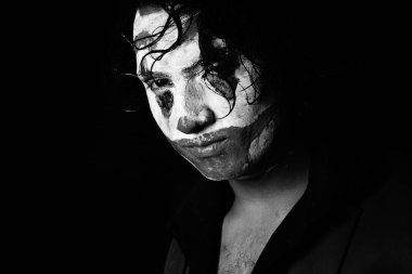 man in joker face makeup, in angry pose,black and whit image