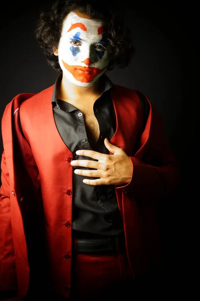 man in joker face makeup , in formal outfit image