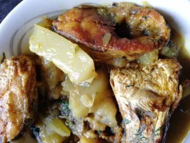 Lezzetli ve sıcak balık körisi. Balık parçaları, karışık baharatlar, şişe kabağı, domates, patates, zeytinyağı, kişniş yapraklarından yapılan geleneksel yemek.