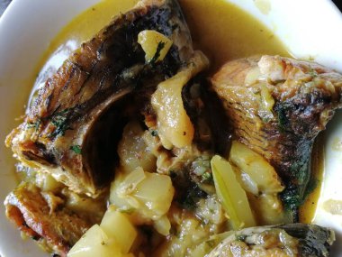 Lezzetli ve sıcak balık körisi. Balık parçaları, karışık baharatlar, şişe kabağı, domates, patates, zeytinyağı, kişniş yapraklarından yapılan geleneksel yemek.