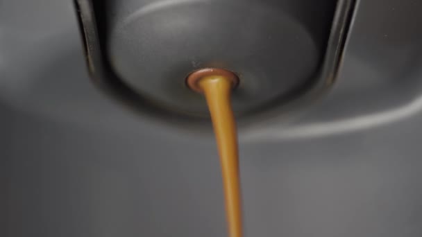 非常に近いマクロショットでカプセルコーヒーメーカーから出てくる新鮮なコーヒーを作った — ストック動画