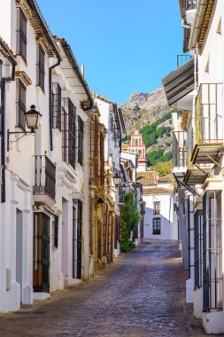 Grazalema, Cadiz, İspanya 'daki eski bir kasaba olan Grazalema' da, dağın eteğindeki beyaz evlerin resimli geçidi.