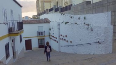 Cadiz 'deki Olvera köyünün tepesindeki katedrale giden basamaklarla sarp sokaklarda gezinen turist kadın.