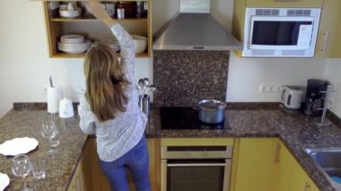 Yetişkin beyaz kadın mutfakta çalışıyor. Aileye yemek hazırlıyor.