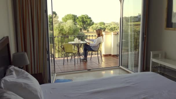Starsza Kobieta Siedzi Tarasie Swojego Hotelu Czytając Książkę Ciesząc Się — Wideo stockowe