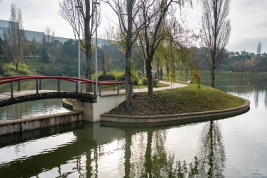 Public park with a large lake and bridges crossing the water above in Tres Cantos, Madrid, Spain