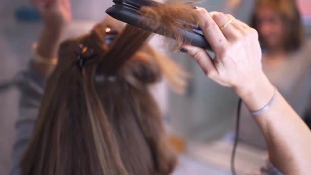 Woman Fixing Her Hair Front Mirror Using Hair Straightener — Stock Video