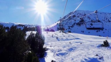 Slowmotion shot ski resort in the Pyrenees with skiers climbed on the ski lift to climb the mountain, Grandvalira, Andorra