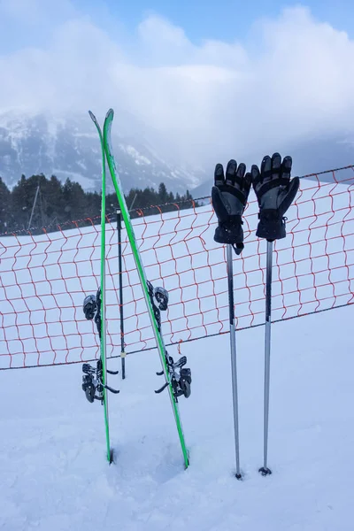 Skis and sticks with gloves, nailed in the snow of the ski slopes in the Pyrenees, Andorra