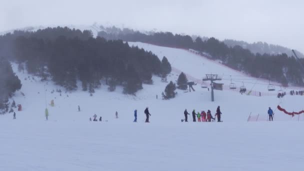 Esquiadores Descendo Pistas Esqui Entre Montanhas Com Canhões Neve Trabalhando — Vídeo de Stock