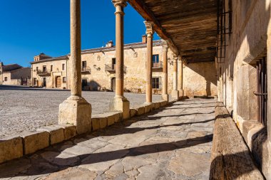 Arcades of the old city of Pedraza with its old roofs supported by stone columns, Segovia, Spain