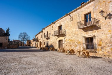 Old stone buildings with grilled balconies and wooden doors in the medieval town of Pedraza, Castile and Leon, Spain