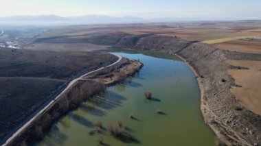 Aerial view from a drone of the course of the river that circulates quietly between the hills, Rio Riaza, Segovia