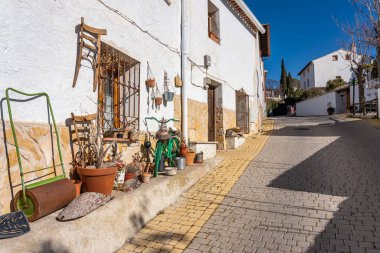 Picturesque alley with white houses and old farming utensils and diverse decoration, Olmeda de las Fuentes