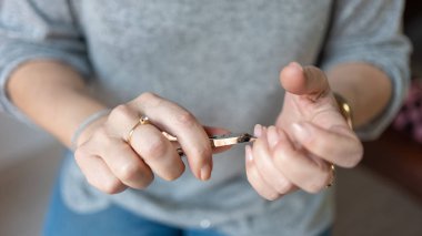 Yaşlı kadınların elleri küçük metal penseyle manikür yaparken.