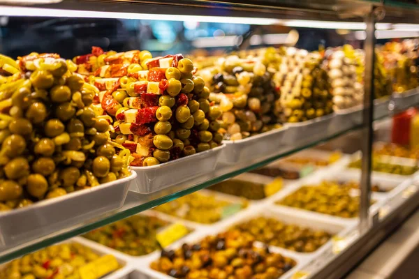 stock image Counter of a market with piles of food, olives and pickles in a colorful exhibition, Mercado San Miguel, Madrid