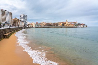 Gijon, Asturias kentindeki binaların eteklerinde geniş bir alana sahip San Lorenzo plajı.