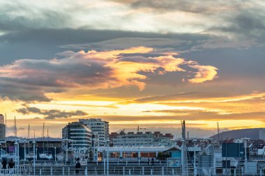 İspanya 'nın Asturias kentindeki Gijon şehrinin marinasında gün batımında altın bir gökyüzü.
