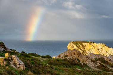 Ufukta görülen fırtınalar tarafından oluşturulan gökkuşağı İspanya 'nın Asturias kıyısındaki uçurumlardan görülüyor.