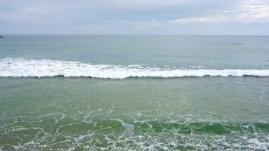 İspanya 'nın Asturias, Gijon kentindeki San Lorenzo sahilinde hafif dalgalar