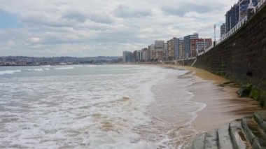 İspanya 'nın Asturias, Gijon kentindeki San Lorenzo sahilinde hafif dalgalar