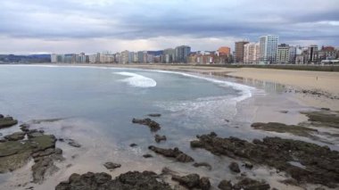 Gijon, Asturias 'taki San Lorenzo plajında deniz dalgaları huzur içinde dalgalanır.