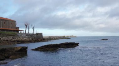 İspanya 'nın Asturias kentindeki Luanco balıkçı köyünde deniz kenarındaki eski taş kilise.