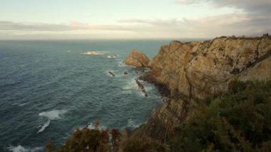 İspanya 'nın Asturian sahilinin burnundaki Cantabrian Denizi' nin tepelerinde altın gün batımı
