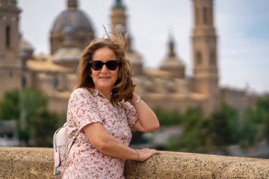 Zaragoza 'daki Pilar Katedrali' nin yanında poz veren turist kadın saçını hareket ettiren güçlü rüzgara dayandı.
