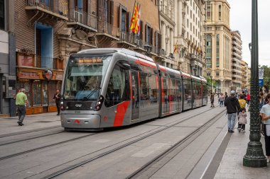 Zaragoza, İspanya - 29 Nisan 2023: Sokakta yürüyen ve tramvay kullanan insanlarla dolu geniş bir cadde