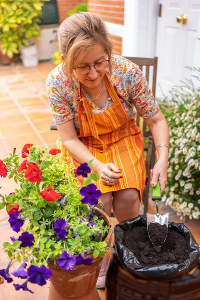 Mujer Madura Sentada Una Silla Jardín Mientras Pone Tierra Compost — Foto de Stock