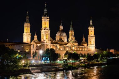 Zaragoza Pilar 'ın katedral bazilikası geceleri Ebro nehrinin yanında aydınlanır, İspanya