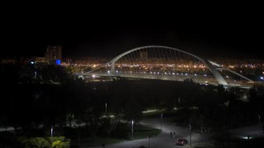 Ebro Nehri 'ni geçen modern bir köprüyle gece Zaragoza şehri manzarası