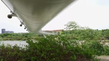 Modern çelik köprü Zaragoza 'da güçlü rüzgarın estiği bir günde Ebro nehrinin üzerinde asılı duruyor.