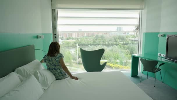 女人放下俯瞰城市的一个大窗户的自动窗帘 — 图库视频影像