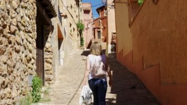 Zaragoza 'nın ortaçağ köyü Anento' da dar bir sokakta yürüyen turist kadın.
