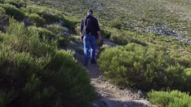 Sırtı dönük bir adam Madrid, Guadarrama 'da dağ yamacında yürüyor.