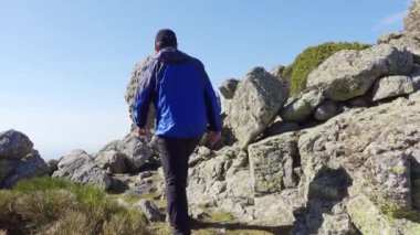 Sırtı kayalık bir dağa tırmanan adam Madrid, Guadarrama arasındaki yolda.