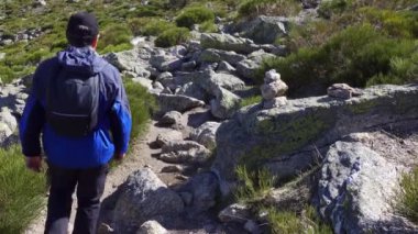 Sırtı dönük bir adam Madrid, Guadarrama 'da dağ yamacında yürüyor.
