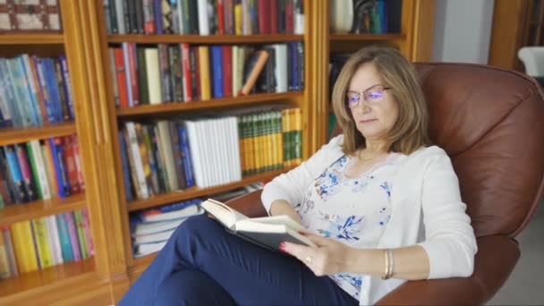 Eine Ältere Weiße Frau Liest Ein Buch Und Sitzt Einem — Stockvideo
