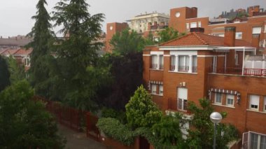 Şehre şiddetli yağmur yağıyor. Binalara ve ağaçlara düşen sular.